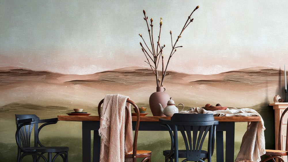 Stylish rustic interior of dining room with walnut wooden table, retro chairs, decoration, fireplace, dried flower, candlestick mock up picture frame and carpet in minimalist home decor. Template.